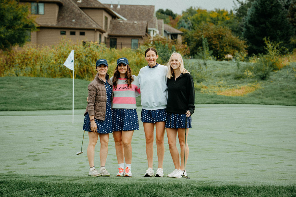 Team of four posing on the green