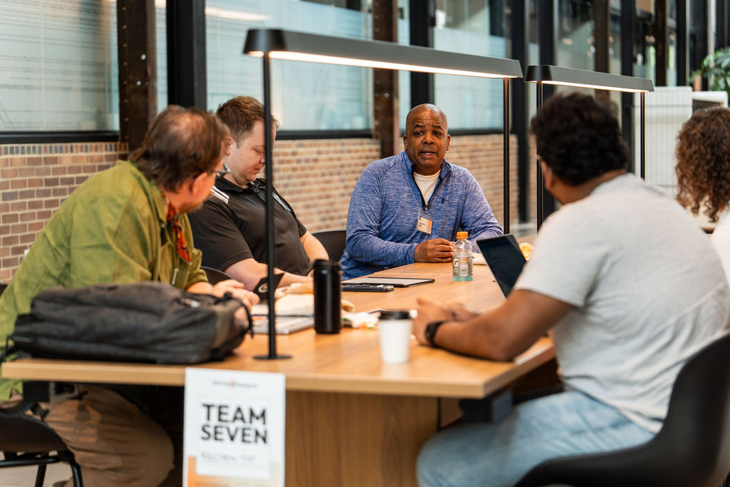 Team Seven working through their idea at a table