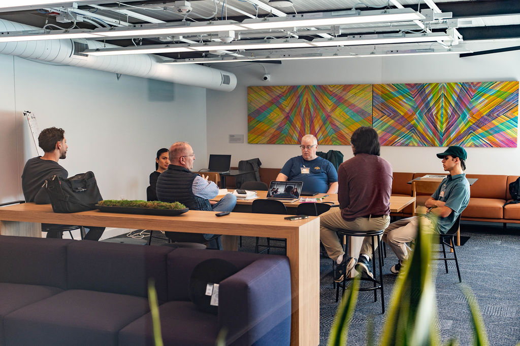 Team brainstorming beneath colorful wall art