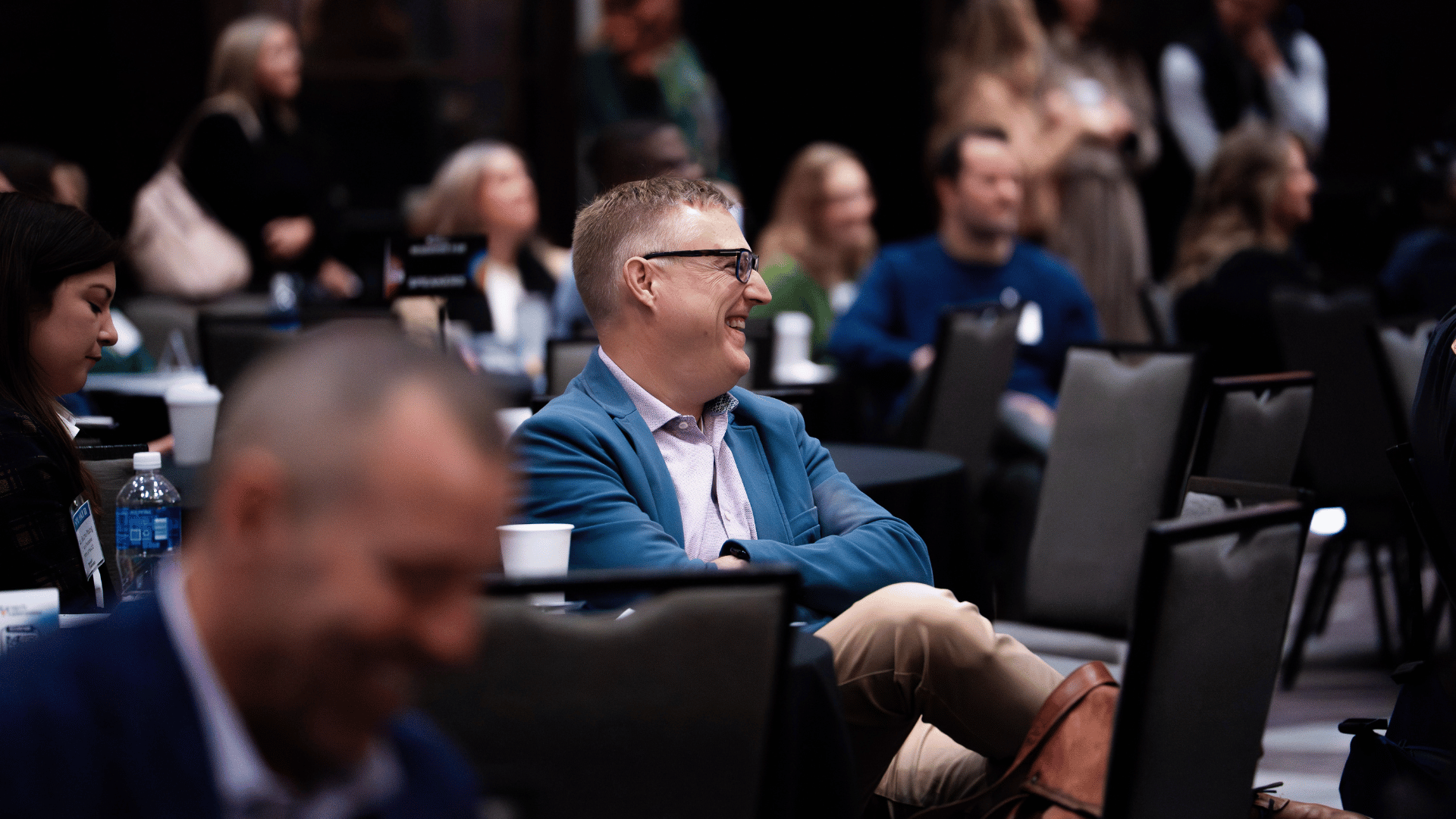 Attendee smiling in the audience during a session