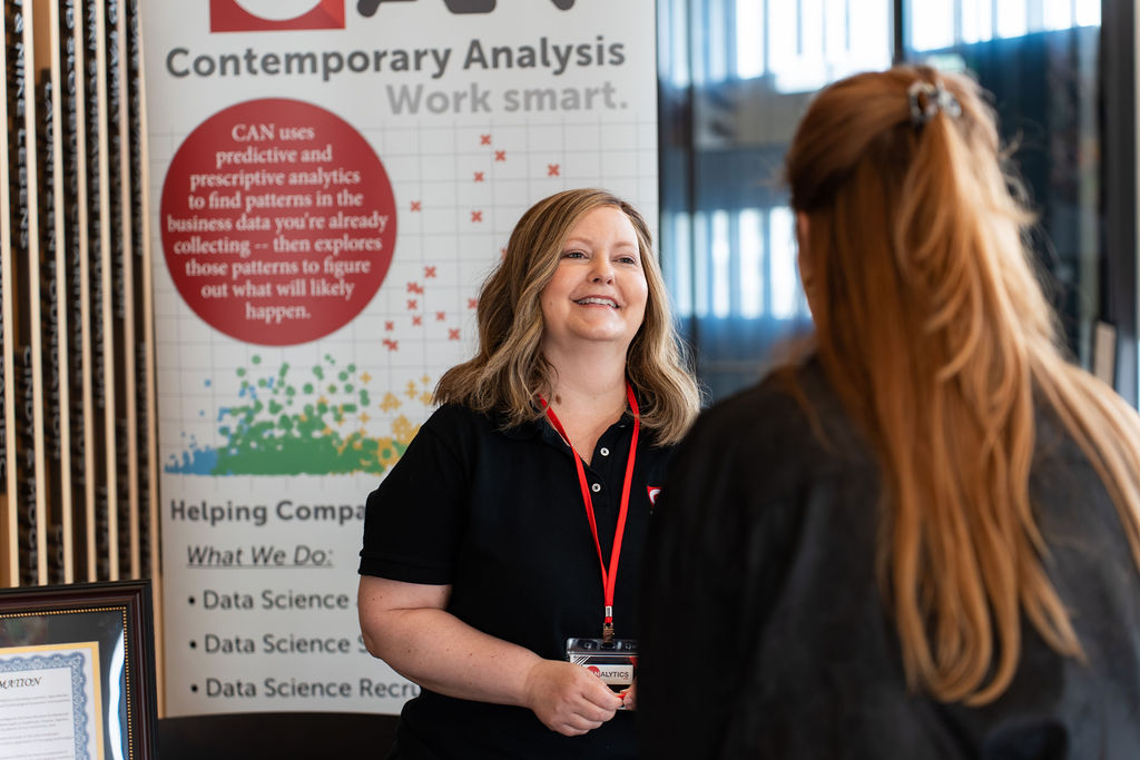 Contemporary Analysis team member greeting a guest at the booth