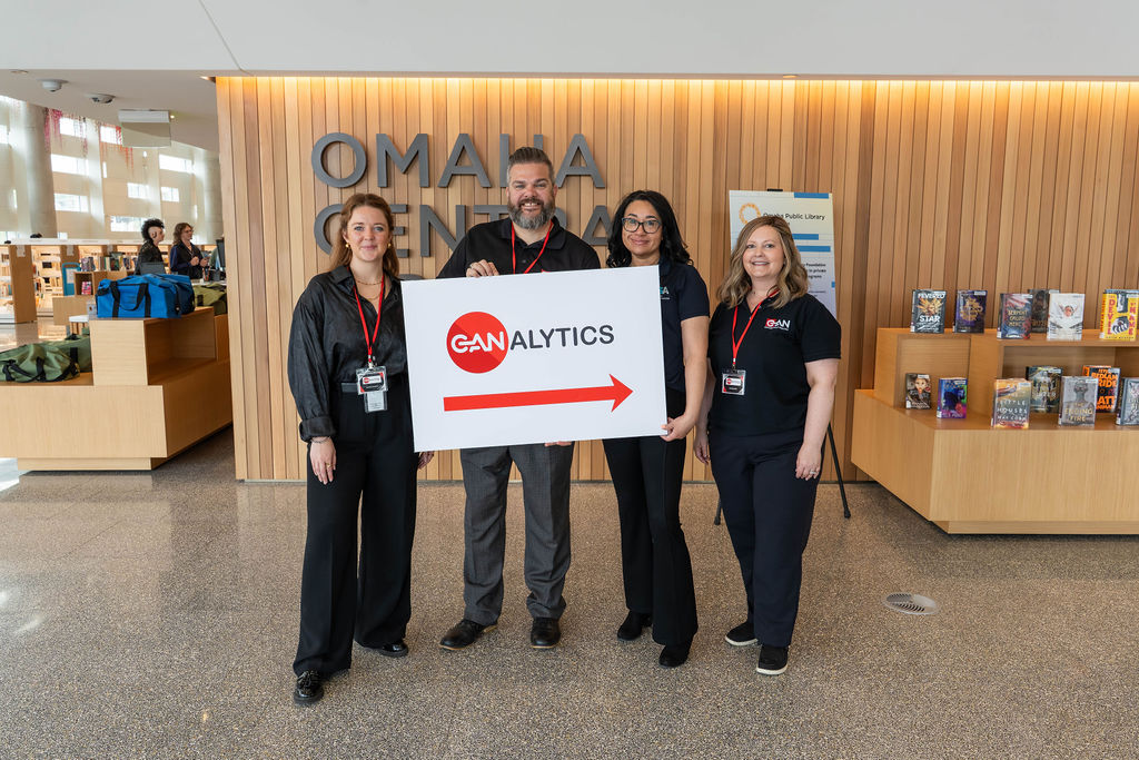 Contemporary Analysis team holding a CANalytics sign at Omaha Central Library