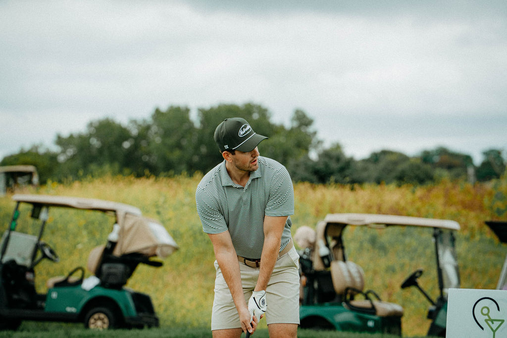 Golfer lining up a shot near the carts