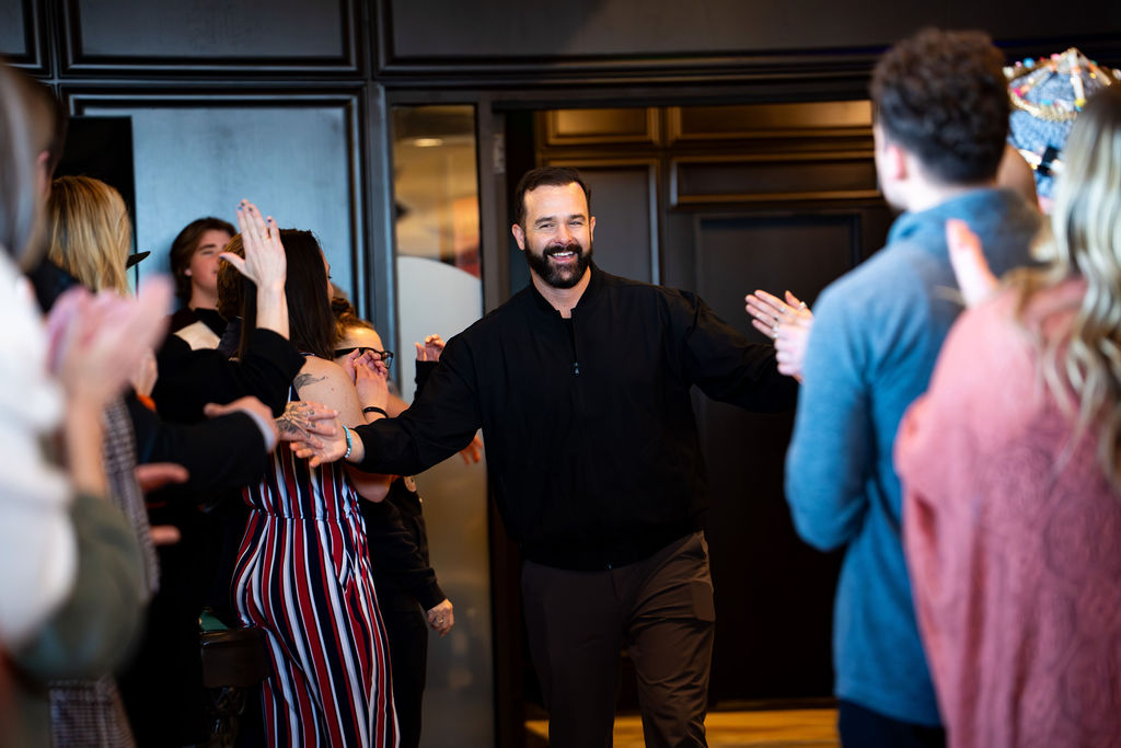 Speaker walking through a high-five tunnel at Becoming the Better You Omaha