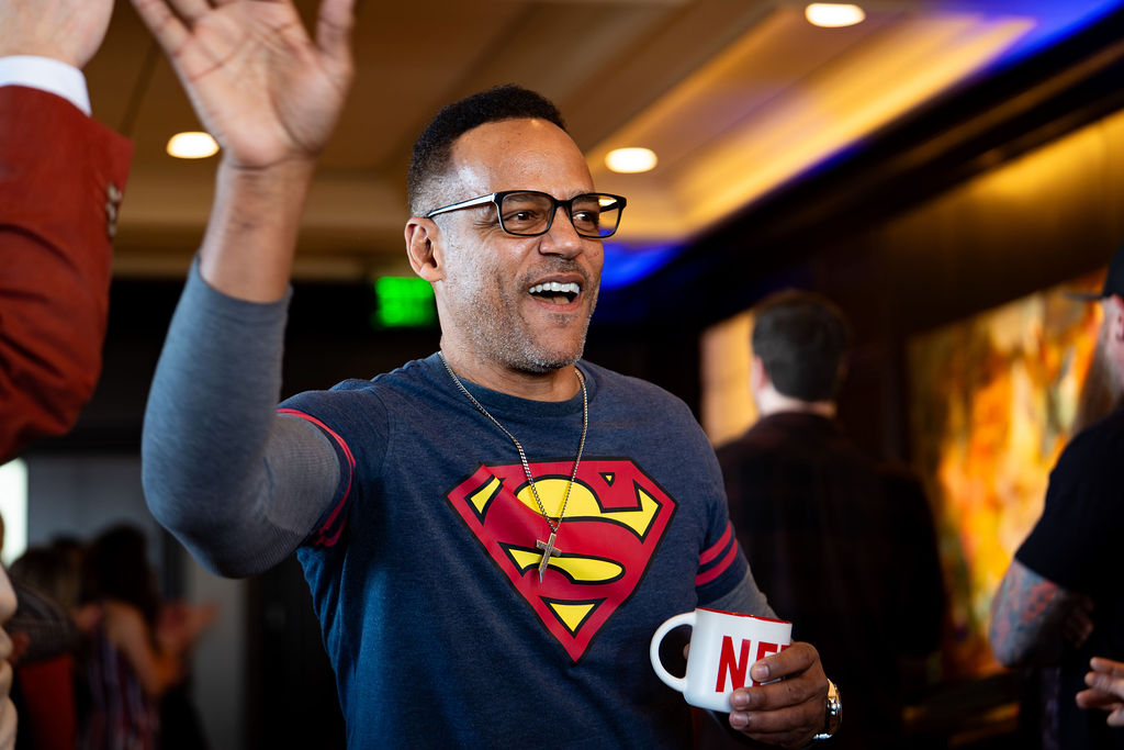Smiling attendee in a Superman shirt giving a high five