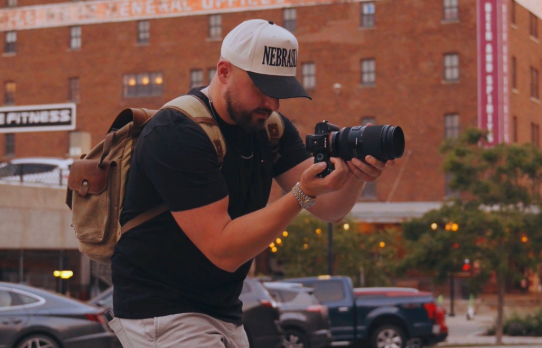 A Peterson Media videographer films a roofing crew on a residential job site at golden hour.